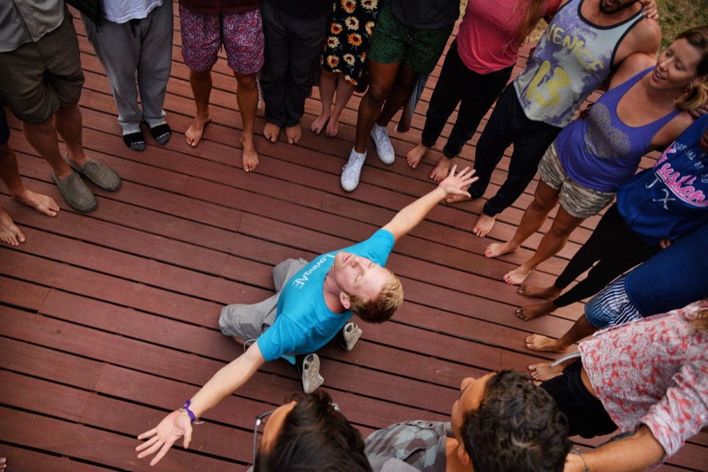 Retreat guest reaching up mid-movement inside a circle