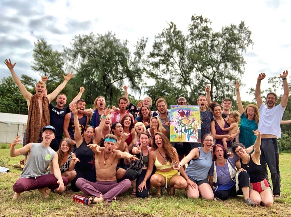 Group celebrating together outdoors with a painted canvas