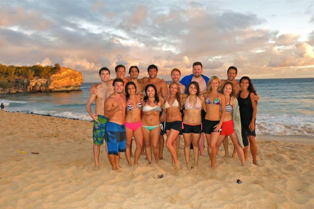 Friends posing together on a beach at sunset