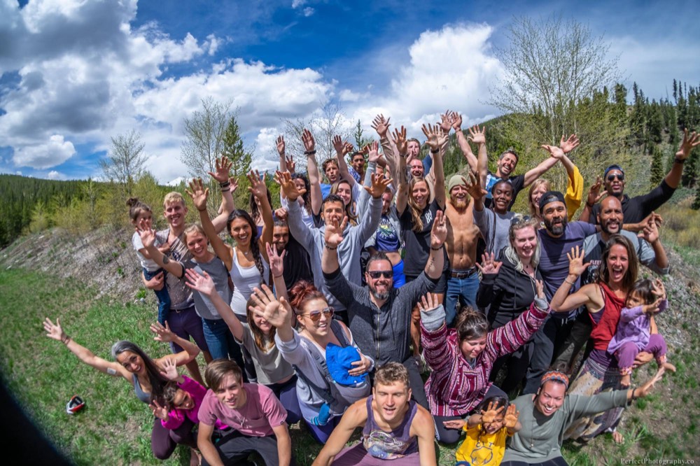 Group with arms raised on a forested hillside