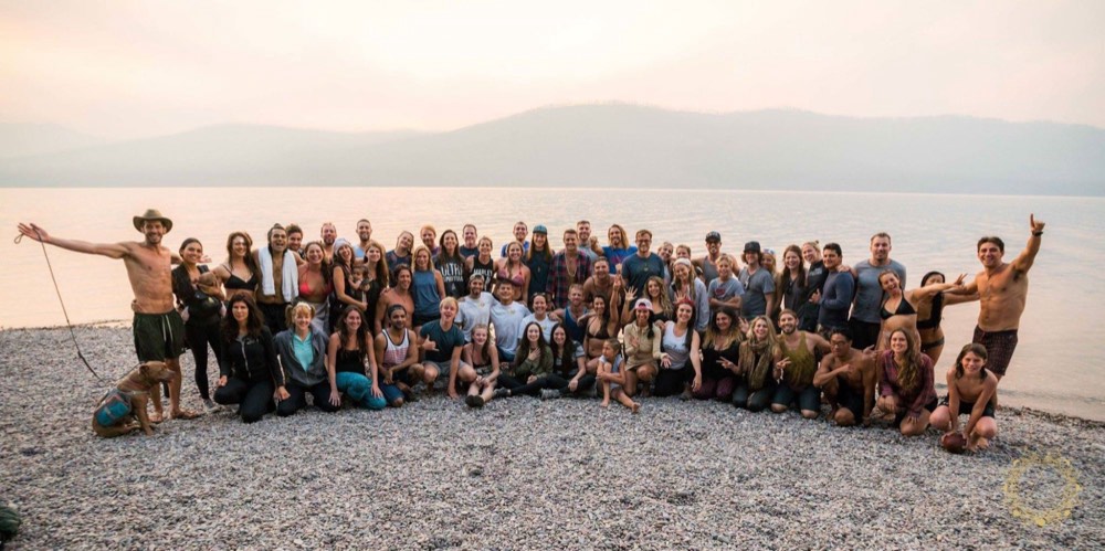 Group photo on a rocky beach at sunset