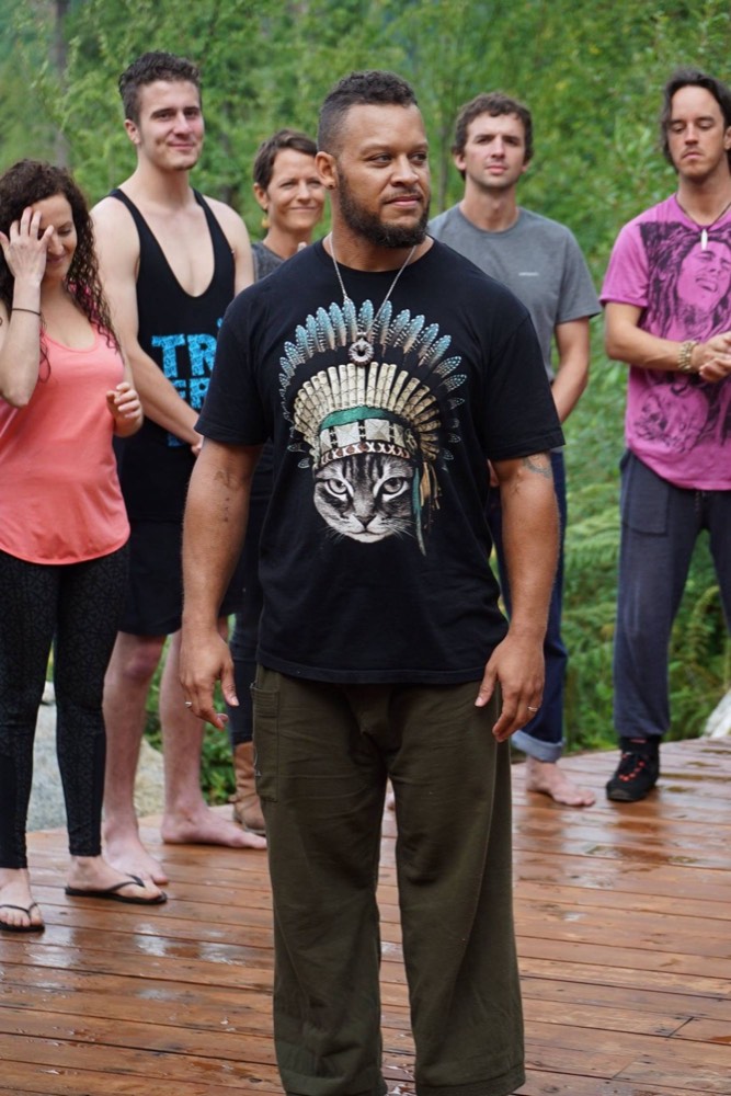 Retreat leader addressing the group in front of a teepee frame